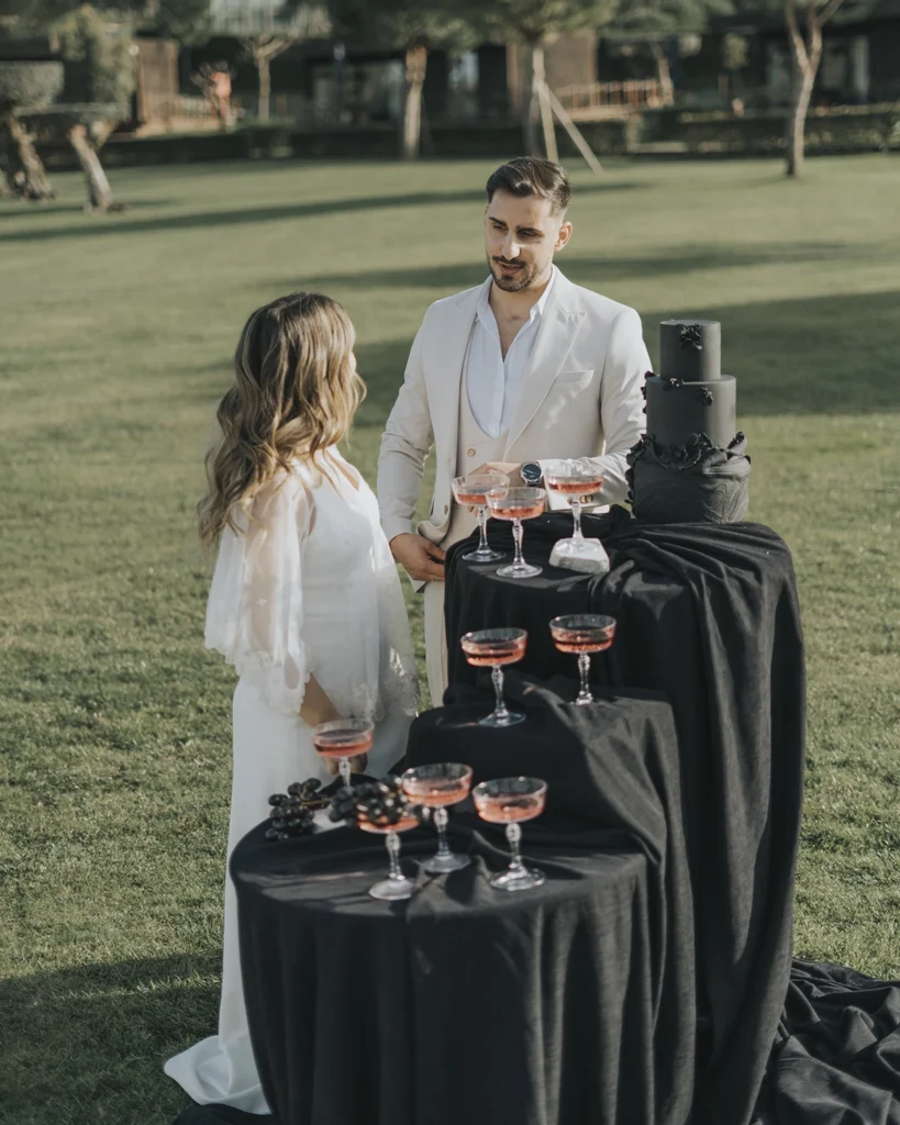 Casal junto ao bolo de casamento, compartilhando um momento especial em meio à celebração.