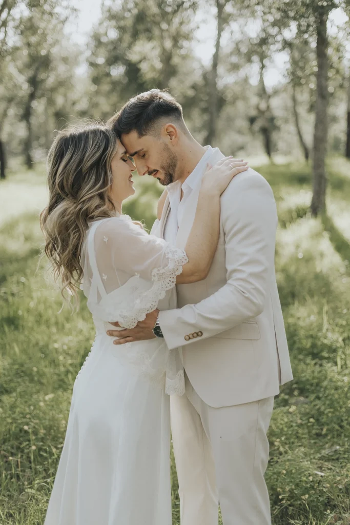 Bride and groom embracing in a forest, surrounded by natural light and greenery – emotional and cinematic wedding photography in Portugal.